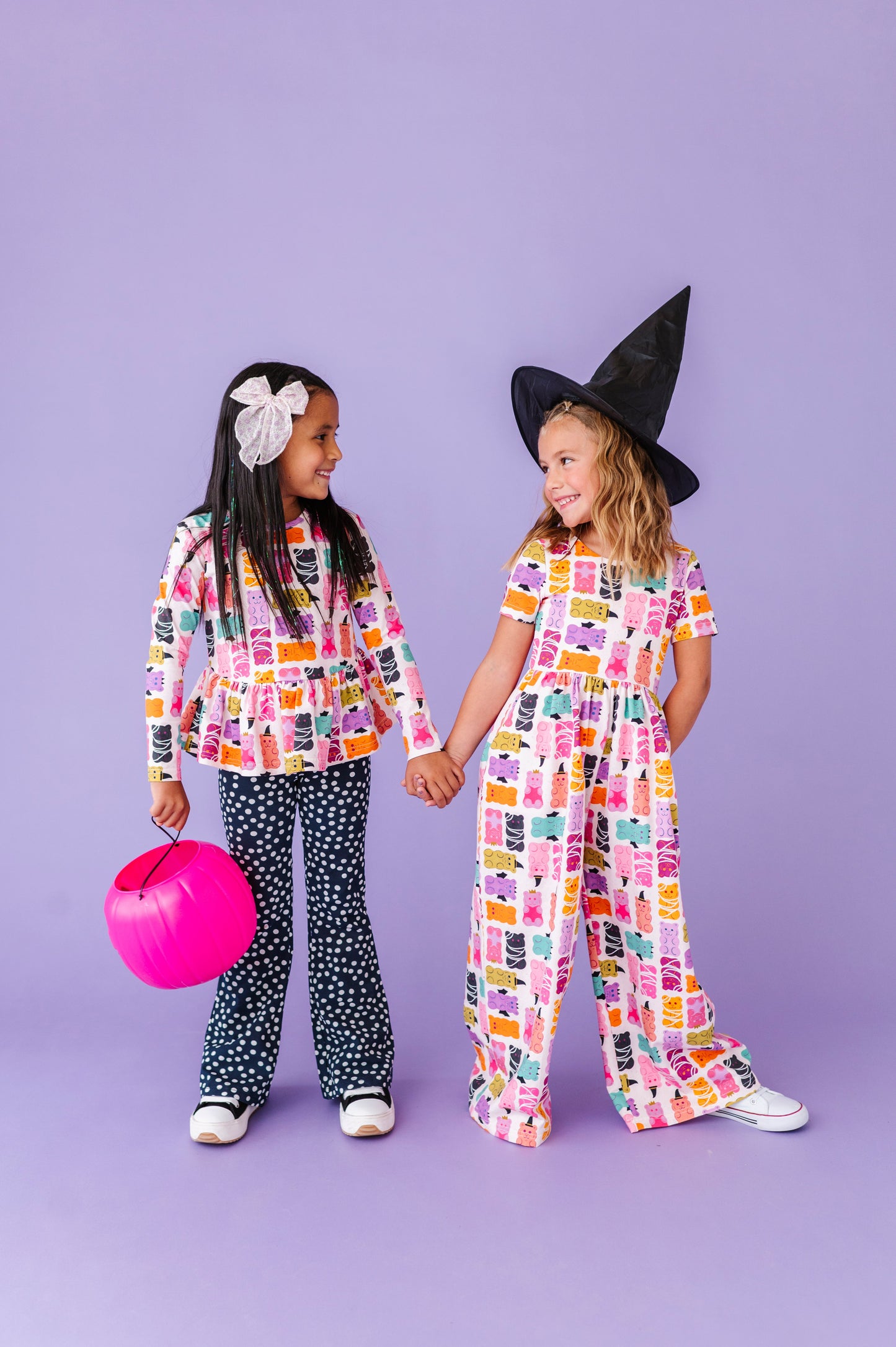 Two children in colorful outfits against a purple background